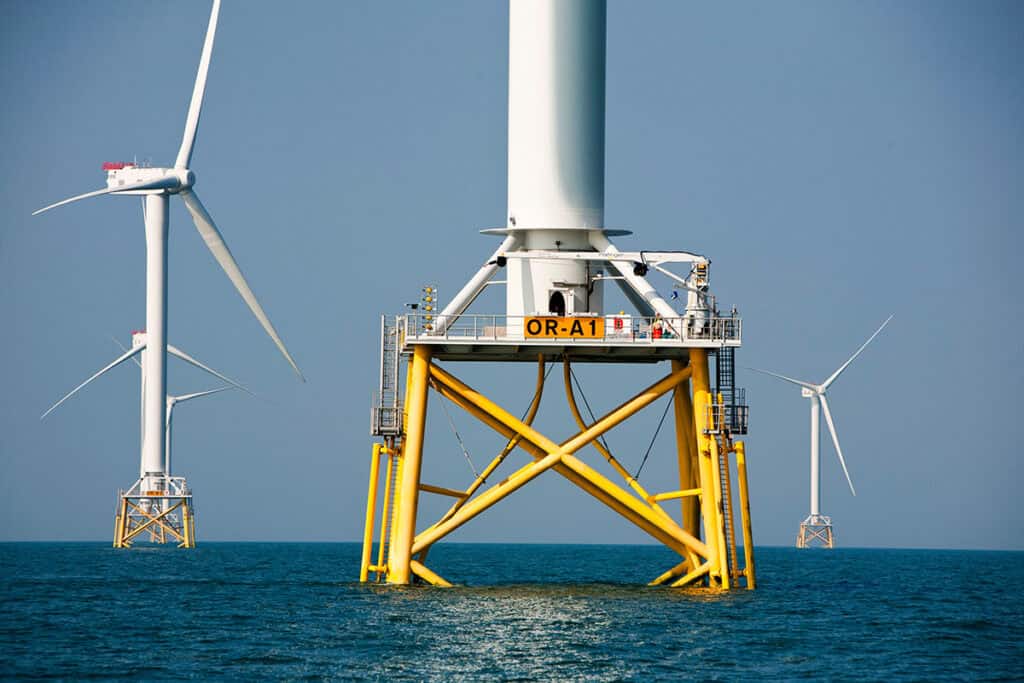 Các turbine gió ngoài khơi đứng trên biển dưới bầu trời trong xanh, khai thác năng lượng gió ngoài khơi. Ở phía trước, PLAXIS và SACS hỗ trợ mô hình hóa địa kỹ thuật, phía xa còn có các kết cấu turbine khác.